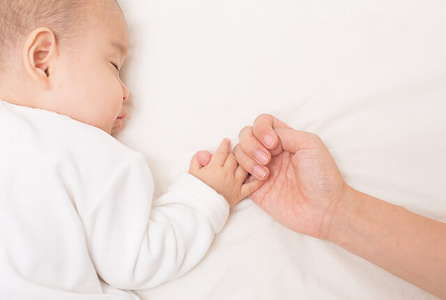 ママの手を握りスヤスヤ眠る赤ちゃん